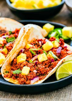 two tacos filled with meat and pineapple salsa