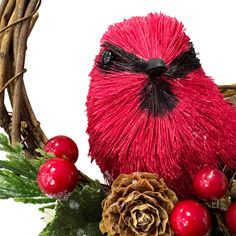 a red bird sitting on top of a christmas wreath