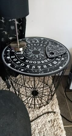 a table with an upside down clock on it and a lamp in the corner next to it