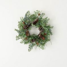 a wreath with pine cones and evergreen needles