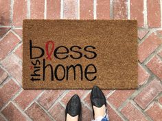 a person standing in front of a door mat that says, bess the home