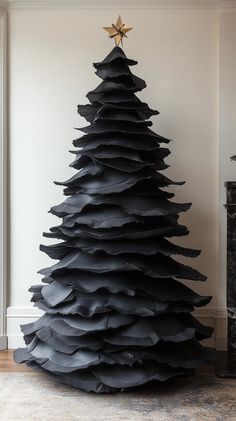 a black christmas tree made out of large piles of folded up paper, with a star on top