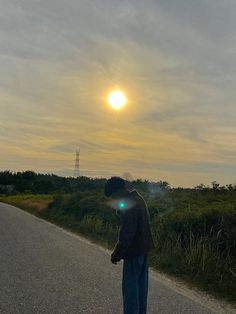 a man standing on the side of a road with his back turned to the camera