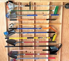 there are many different types of tools on the shelf in this garage storage rack that is filled with shovels, rakes, and other household items