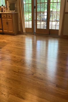 an empty living room with wood floors and sliding glass doors