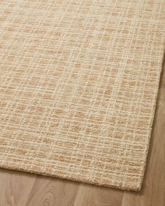 an area rug on the floor with wooden floors and hard wood planks in the background