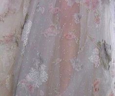 the back of a woman's wedding dress with flowers on it and sheer sleeves