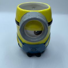 a yellow and blue minion mug sitting on top of a table