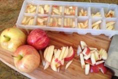 an image of apples and cheese on a cutting board with ice cube trays next to them