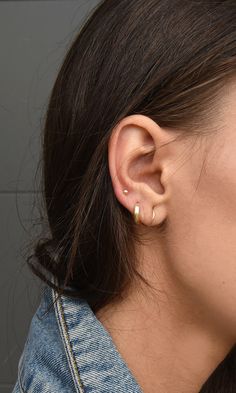 a close up of a person's ear with an earring in the middle