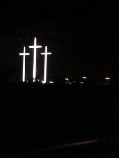 three crosses lit up in the dark at night