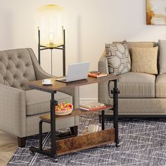 a living room with two couches and a laptop on the coffee table in front of it