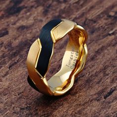 a gold and black ring sitting on top of a wooden table