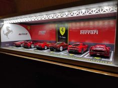 a display case filled with model cars in front of a ferrari store