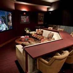 an image of a home theater room with chairs and a table in front of the screen