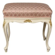 an antique white bench with pink upholstered cushion