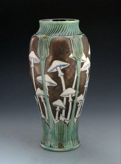 a green and brown vase with mushrooms on it