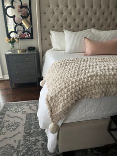 a bedroom with a bed, dresser and mirror in the corner that has a large rug on top of it