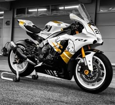 a white and yellow motorcycle parked in front of a building