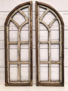 two old wooden windows are shown against a white wall