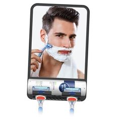 a man shaving his face in front of a mirror with two razors on it