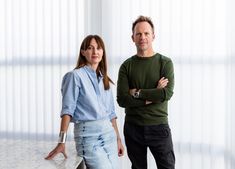 a man and woman standing next to each other in front of a marble counter top