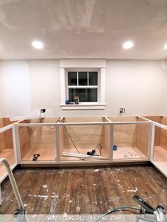 an unfinished room with wooden floors and white walls