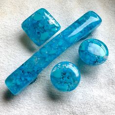 three pieces of blue glass sitting on top of a towel