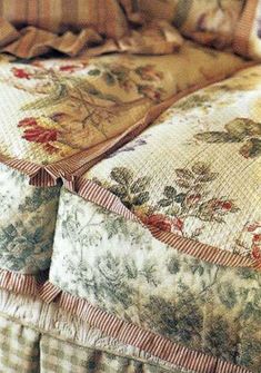 an old fashioned bed with ruffled pillows and quilts on the comforter is shown