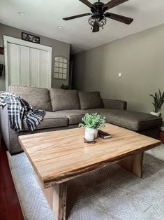 a living room with a couch, coffee table and ceiling fan in the middle of it