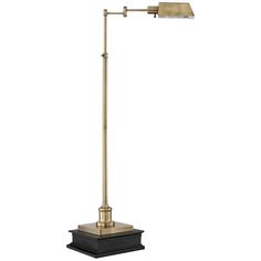 a brass colored floor lamp with a black base and a white shade on the top