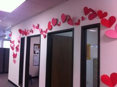 an office cubicle decorated with paper hearts on the wall and two doorways to each side