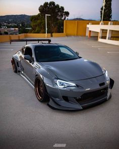 a grey sports car parked in a parking lot