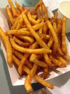 french fries in a box with dipping sauce on the side