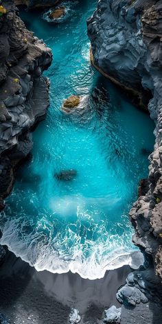 an aerial view of the water and rocks in a river that is blue with white foam