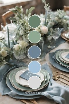 the table is set with blue and green plates, silverware, and white flowers