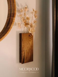 there is a wooden vase with flowers in it on the wall next to a mirror