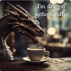 a dragon statue sitting next to a cup of coffee