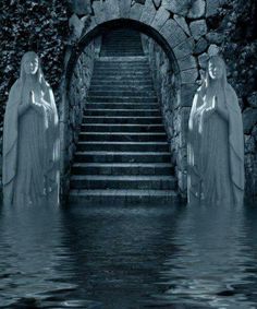 two statues standing in the water next to a stone wall and stairs that lead up to an entrance