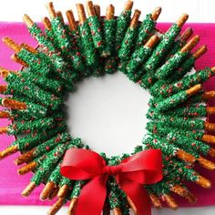 a christmas wreath made out of pretzels with a red bow on the front