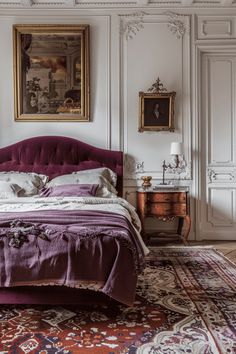 a bedroom with a bed, rug and paintings on the wall