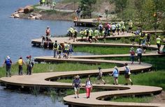 many people are walking on wooden steps near the water