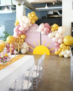 a table with white chairs and balloons on it