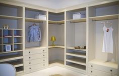 an empty walk in closet with white drawers