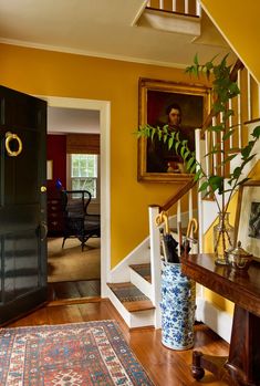 a foyer with yellow walls and wooden floors