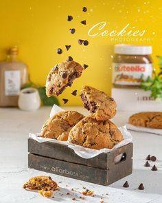 chocolate chip cookies falling into a wooden box