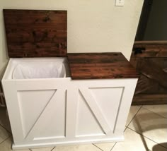 two wooden storage bins sitting on top of a tile floor next to a wall