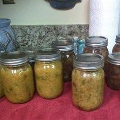 several jars filled with different kinds of food on a table next to a red towel