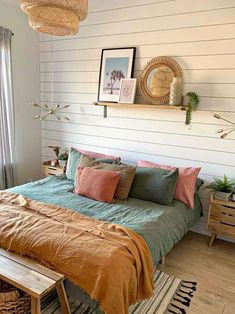 a bed sitting in a bedroom next to a wooden table and window with pictures on the wall