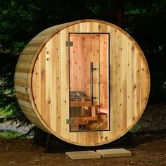 a wooden barrel sauna is shown in the woods